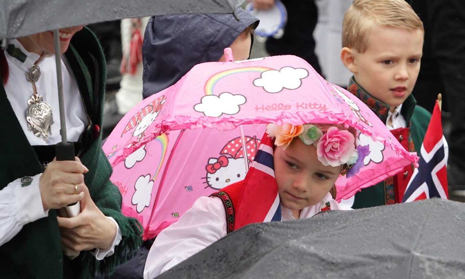 Rosa paraply og roser i håret. (Foto: Kjetil Vasby Bruarøy)