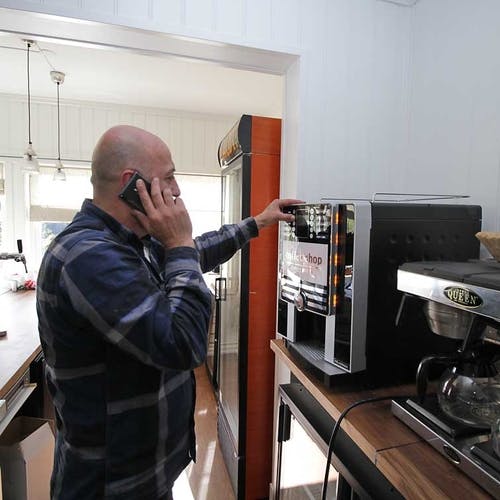 David får instruksjon om kaffimaskina. (Foto: KVB)