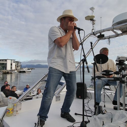 «Bosse» vil by på livemusikk kvar helg. Her speler han munnspel i båten sin i Os hamn. (Arkivfoto: KVB)