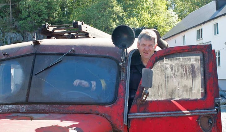 Arne Monsen i døra på den gamle brannbilen, som berre har gått 4924 km på vegen (foto: Andris Hamre)