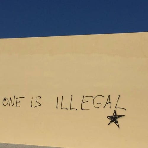 Denne graffitien tyder på at flyktningene er et betent tema på øya. (Foto: Os vgs)