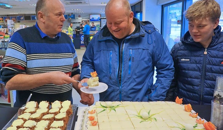 Børge Lunde (midten) og sonen Erik fekk dei første stykkene på Rolf og resten av Tveit-familien sin kakefest i dag. (Foto: Kjetil Vasby Bruarøy)