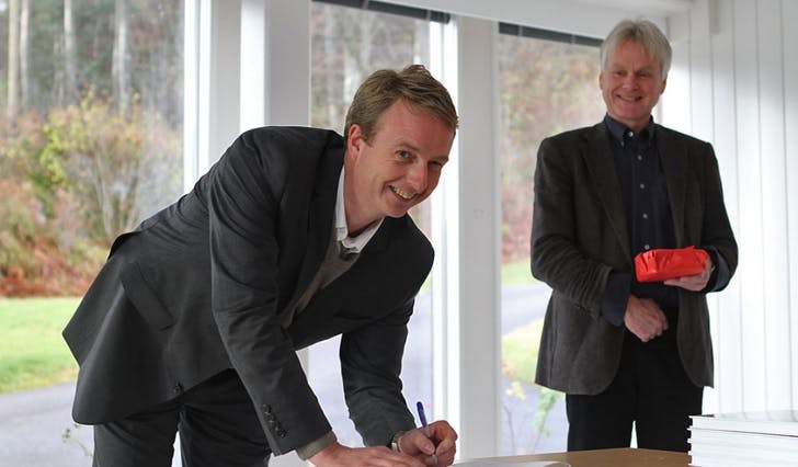 Terje Søviknes signerte kontrakten med eit smil. I bakgrunnen står avdelingsdirektør Askjell Utaaker frå Helse-Bergen. (Foto: Kjetil Vasby Bruarøy)