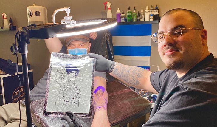 Maury (25) synar fram tatoveringa som kunden, Mathew, sjølv har teikna. (Foto: Ørjan Håland)