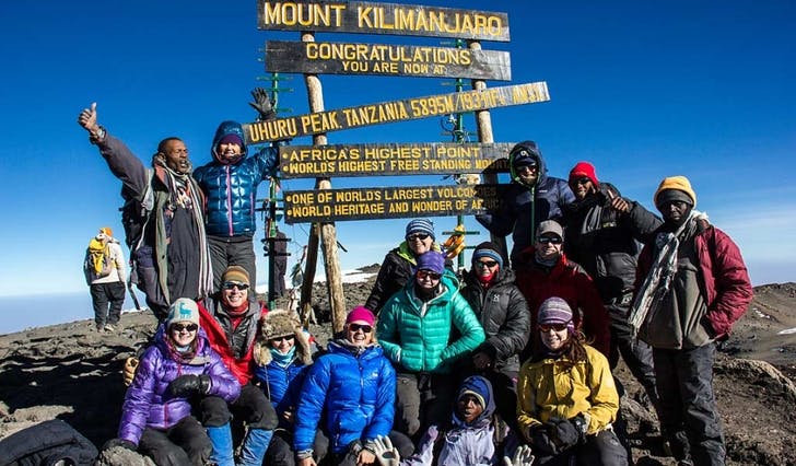 Beate (i midten bak med blå og kvitstripete lue) og gjengen på toppen av Kilimanjaro. (Foto: Privat)
