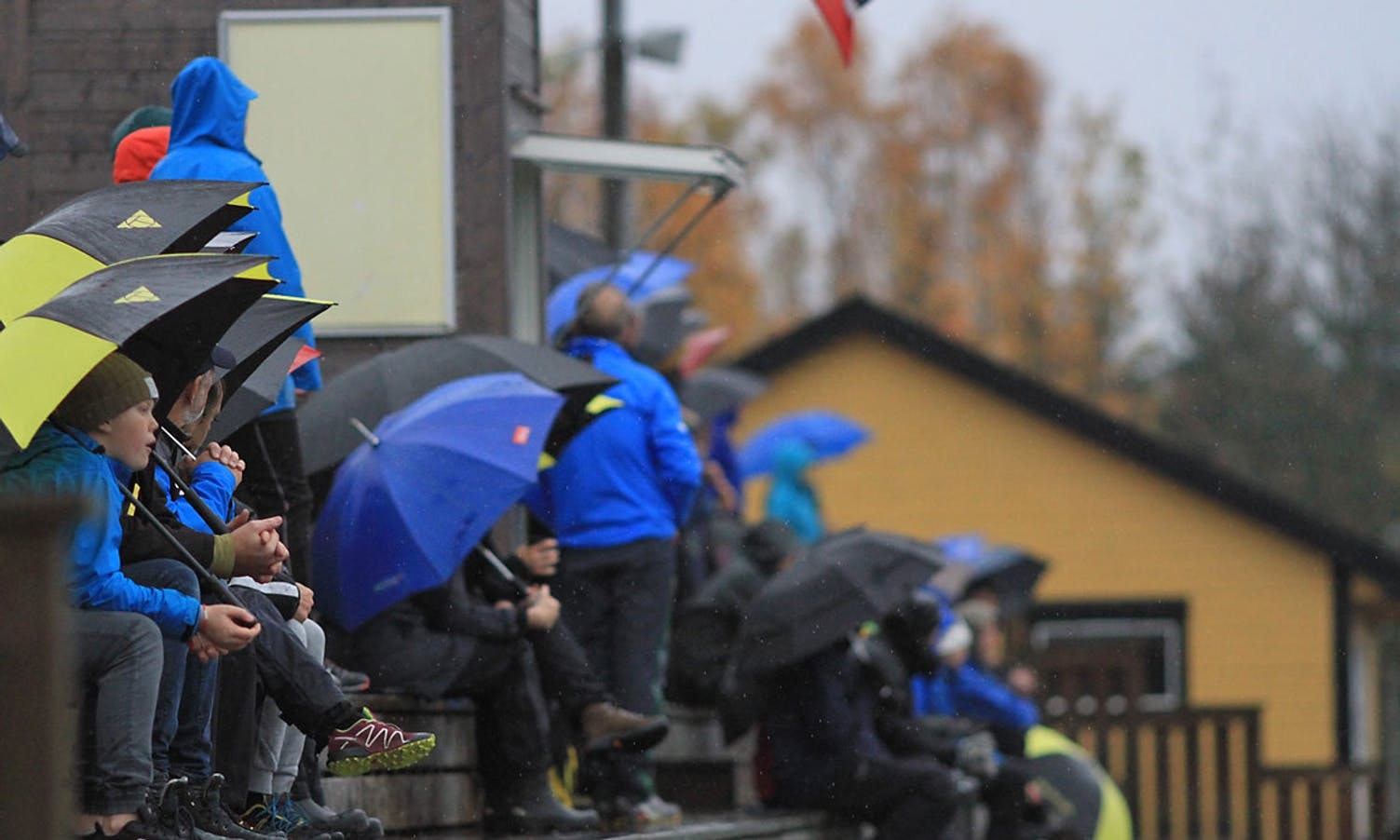 Tungt med nedbør, men Os-fansen har paraply. (Foto: KOG)