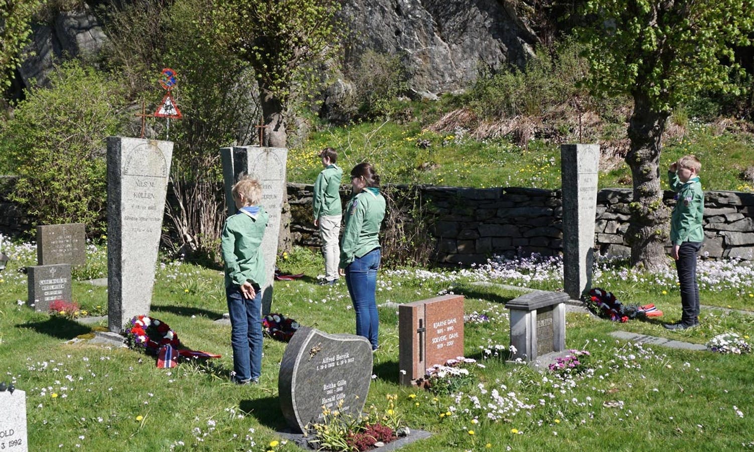 Speidarar frå Os KFUK-KFUM la ned blomer på sju graver på kyrkjegarden (foto: AH)
